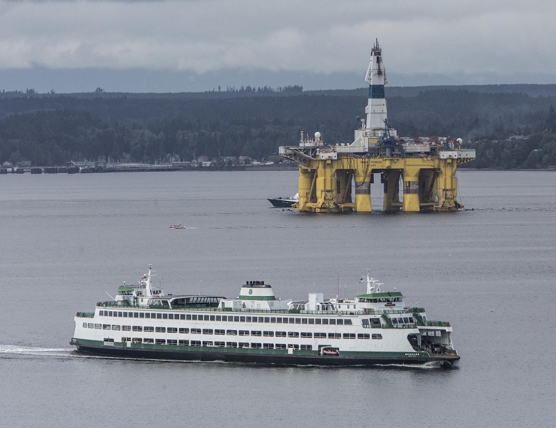 The ferry, Spokane heading for Edmonds crosses the path of the Polar Pioneer being towed to Terminal 5 in Seattle from Port Angeles.   (Steve Ringman / The Seattle Times)